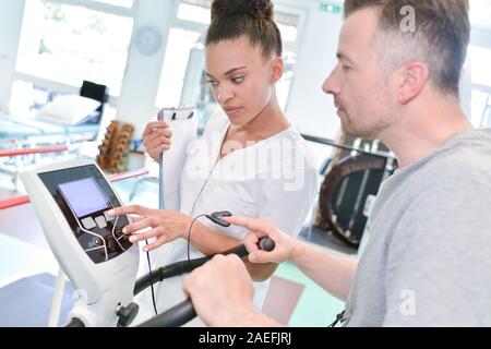 nurse measuring patients blood pressure during exercise electrocardiography Stock Photo