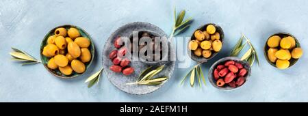 Olives flat lay panorama, top shot. Black, green and red olives of various sizes Stock Photo