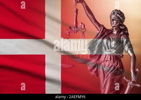 Figure of Justice holding scales on a Danish flag Stock Photo
