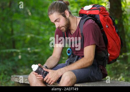 hiker sitting on a rock looking down Stock Photo