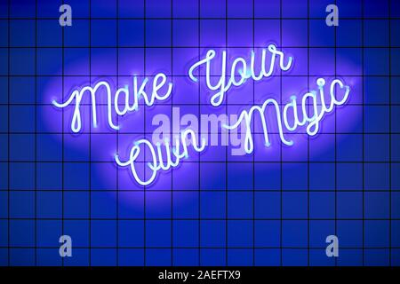 Handwritten neon glowing text Make Your Own Magic on blue tiled wall. Trendy classic color. Luminescent illuminated lamp Stock Photo