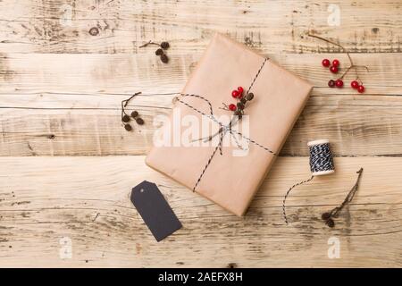 Top view on Christmas gift wrapped in craft and decorated with various natural things. DIY present idea. Holidays concept. Stock Photo