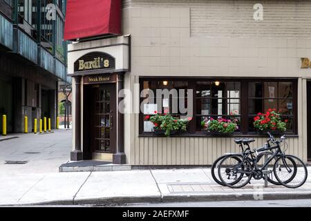 Toronto, Canada, October 03, 2018 : In the streets of Toronto, The famous bardi's steak house restaurant with two bycicles in the front. Stock Photo
