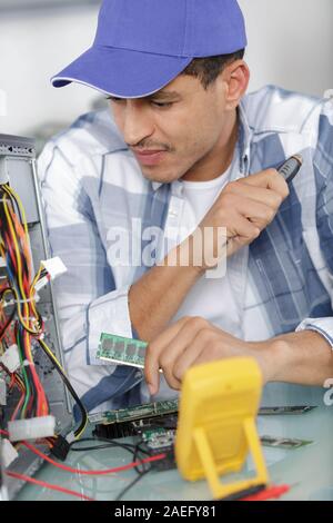 technicians working on broken computer in workshop Stock Photo