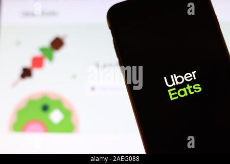 Los Angeles, California, USA - 21 November 2019: Uber Eats logo on phone screen with icon on laptop on blurry background, Illustrative Editorial. Stock Photo