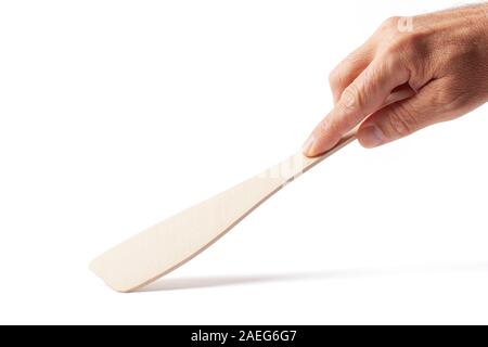 New wooden cooking spatula in a human hand isolated on white. Image with clipping path. Stock Photo