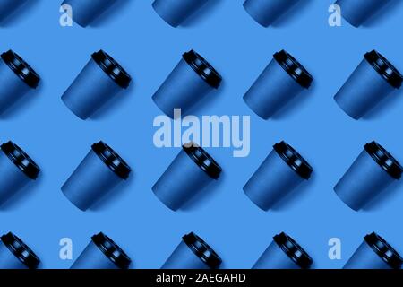 Seamless pattern of many coffee to go paper cups on grey background. Open composition. Flat lay style. Stock Photo