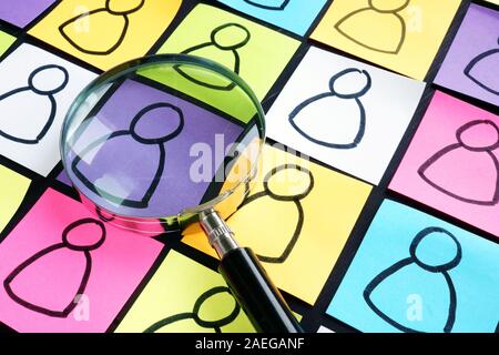 Customer Segmentation concept. Multicolored sheets with figures and magnifying glass Stock Photo