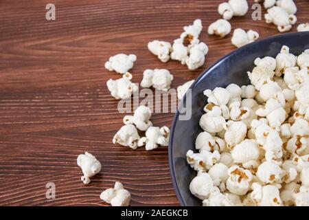 Pop corn snack in bowl, on the wooden table. Top view, banner mockup for cinema and tv movie Stock Photo
