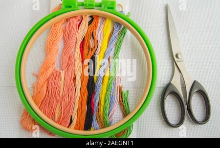 The concept of needlework. Sewing accessories for embroidery-canvas, Hoop, thread floss, flat lay, top view. Stock Photo