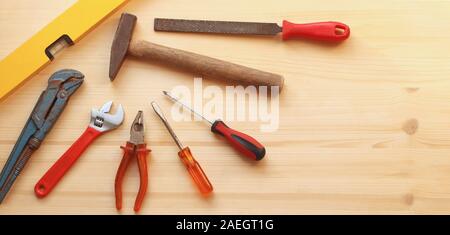web banner with basic tools for DIY like hammer and pliers on a wooden background with copy space Stock Photo