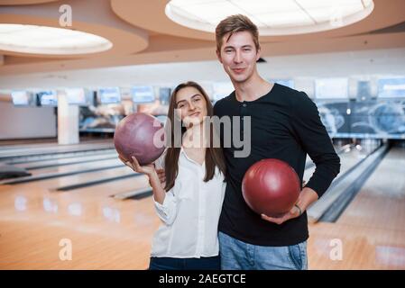 Big hall. Young cheerful friends have fun in bowling club at their weekends Stock Photo