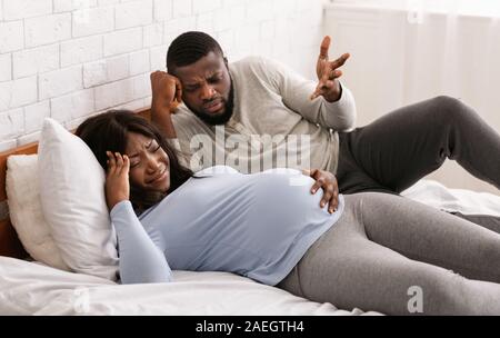 Pregnant black couple having fight in home interior Stock Photo