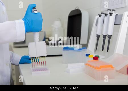 Hand of medical assistant or doctor filling test tubes Stock Photo
