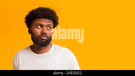 Doubtful young man looking at free space Stock Photo