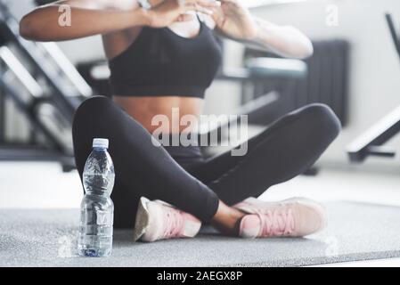 Yoga is good way to relax your body and mind. Particle view of sportive girl in the gym sitting on the floor at her weekends Stock Photo