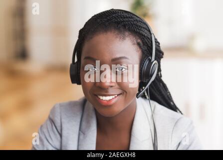 Portrait of friendly afro female customer service operator in headset Stock Photo