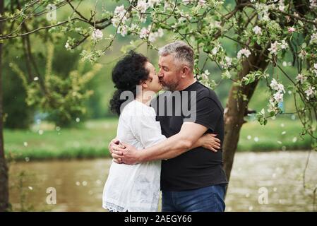 Giving a kiss. Cheerful couple enjoying nice weekend outdoors. Good spring weather Stock Photo