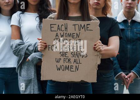 Concentration at poster. Group of feminist women have protest for their rights outdoors Stock Photo
