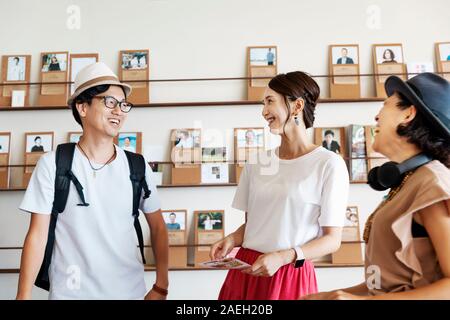 Group of young Japanese professionals talking to each other in a co-working space. Stock Photo
