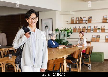 Group of young Japanese professionals working on laptop computers in a co-working space. Stock Photo