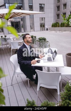 Concentrated brunette male being deep in thoughts Stock Photo