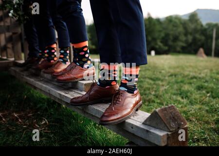 stylish men's socks. Stylish suitcase, men's legs, multicolored socks and new shoes. Concept of style, fashion, beauty and vacation. Stock Photo