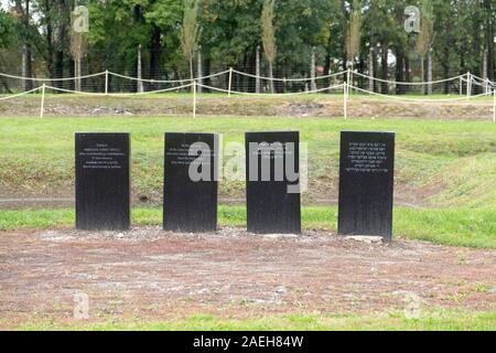 Gravestones mark the pits where the remains of the people murdered were buried. The incinerators of crematorium II and Gas Chambers at Auschwitz II-Bi Stock Photo