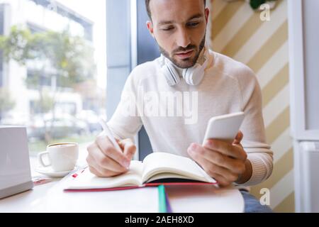 Close up of serious man that making notes Stock Photo