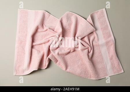 Crumpled pink towel on grey background, top view Stock Photo