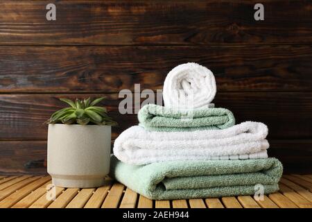 https://l450v.alamy.com/450v/2aeh944/towels-and-succulent-plant-on-bamboo-table-against-wood-background-space-for-text-2aeh944.jpg