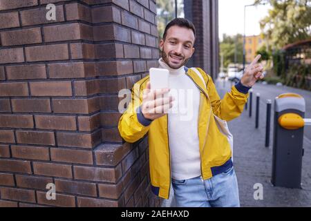 Positive delighted brunette man pointing at next building Stock Photo