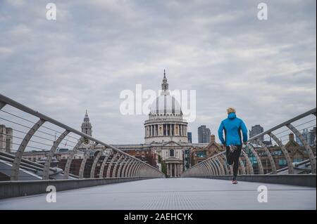 London marathon concept photo. Runner training on Millennium Footbridge, St Paul's Cathedral in background. Stock Photo