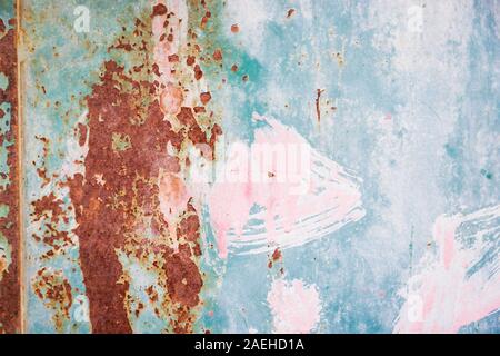Rusty metal surface with pink, green, blue, turquoise paint flaking. Old cracked paint pattern, cracking texture Stock Photo