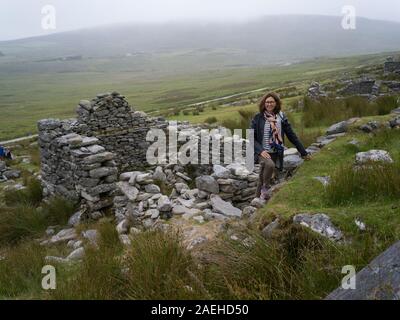 Women standing on the ruins of deserted village, Achill Island, County Mayo, Ireland Stock Photo