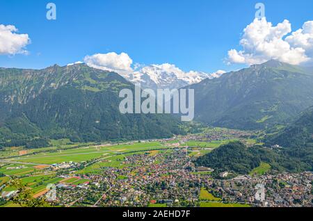 Stunning view of Interlaken and adjacent mountains photographed from the top of Harder Kulm in Switzerland. Swiss Alps landscape. City in the Alpine valley surrounded by mountains. Sunny day. Stock Photo