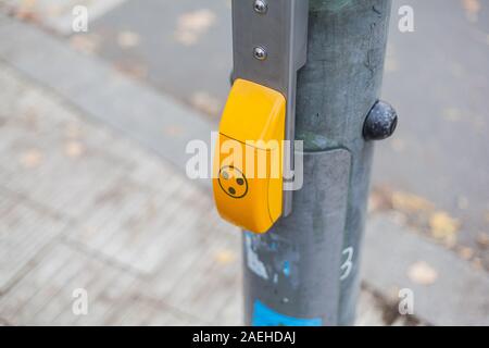 Yellow Traffic light switch for pedestrian crossing and guidance system in Berlin Stock Photo