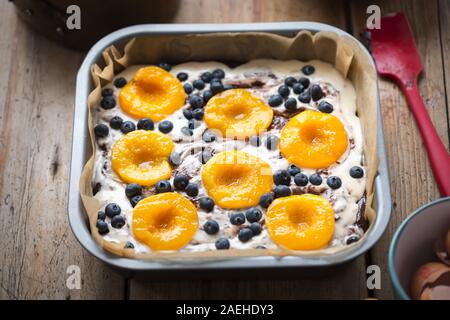 Unbaked oven ready cheesecake brownie cake with apricots and blueberries Stock Photo