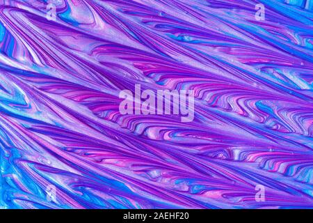 Close up liquid luxury blue and pink metallic glitter paint swirls to make an abstract textured background Stock Photo