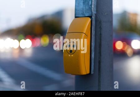 Traffic light switch for pedestrian crossing and blurred car lights in Berlin Stock Photo