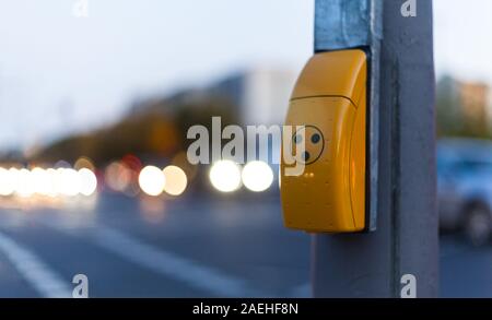 Traffic light switch for pedestrian crossing and blurred car lights in Berlin Stock Photo