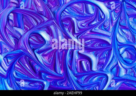 Close up liquid luxury blue and pink metallic glitter paint swirls to make an abstract textured background Stock Photo