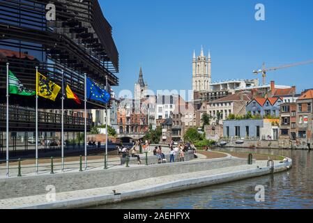 Young people in front of the public library De Krook, and view over the belfry and St Bavo Cathedral towers in the city Ghent, East Flanders, Belgium Stock Photo
