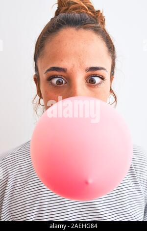 Young readhead modern woman chewing gum and doing air bubble Stock Photo