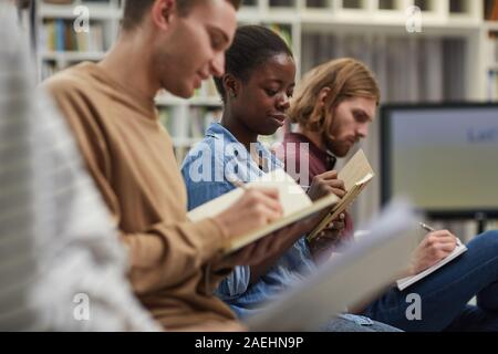 Group of students sitting and writing in their notebooks during lecture at university Stock Photo