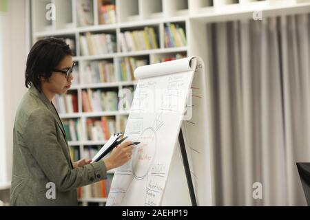 Asian young man writing business strategy on whiteboard and preparing for presentation Stock Photo