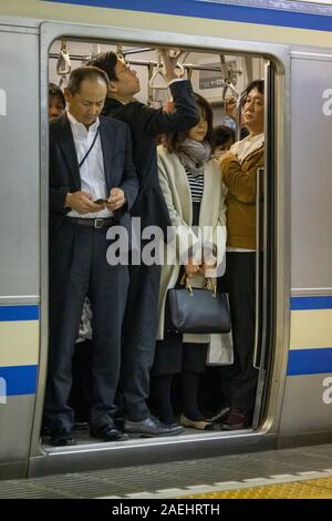 commuters on metro train,Tokyo Station, Japan Stock Photo