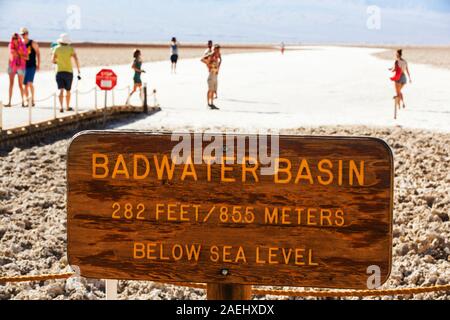 Tourists on salt pans Badwater in Death Valley which is the lowest, hottest, driest place in the USA, with an average annual rainfall of around 2 inch Stock Photo