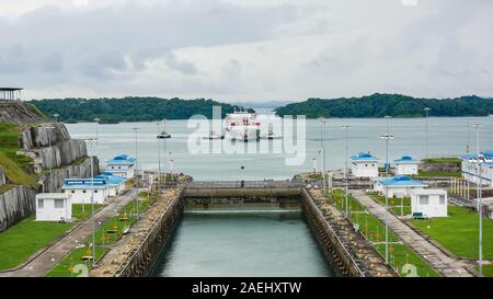 Container ship being maneuvering by tugboats waiting to enter the locks Stock Photo