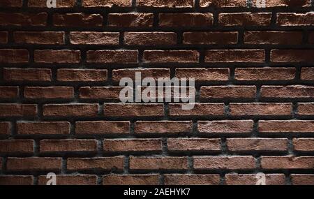 Dark red brick wall with top illumination effect. Background photo texture Stock Photo